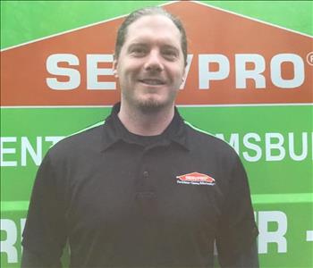 Nick standing in front of Servpro vehicle
